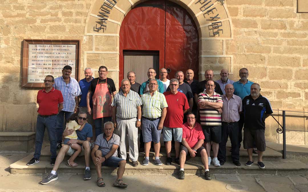 Fotografía de grupo de la veintena de quintos de Pueyos que subieron a la ermita el pasado viernes. Se encargan de tareas como la limpieza y la jardinería de todo el templo y sus exteriores de 8.00 a 10.00. A esa hora paran y se reúnen en torno a la mesa para tomar el almuerzo que han preparado los cocineros