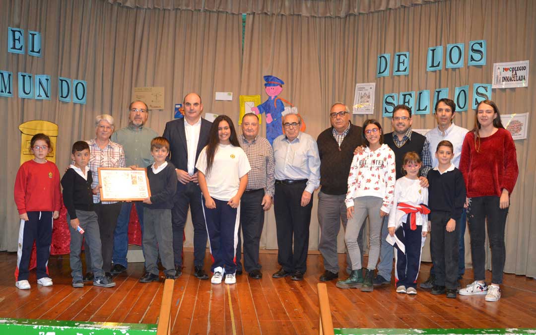Foto de familia de los alumnos ganadores de los dos concursos junto con la dirección del colegio, la asociación Filatélica de Alcañiz y el alcalde, este jueves. l. castel