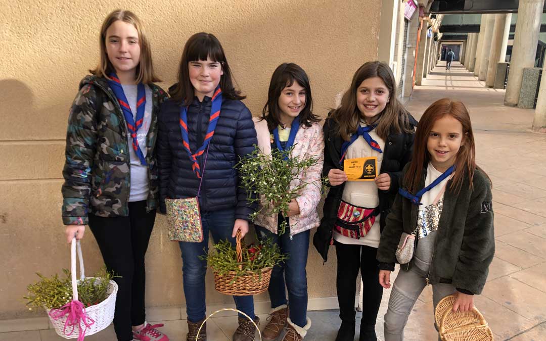 Integrantes de los Scouts vendiendo muérdago.