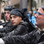 Tres cofrades se toman un respiro durante la procesión del Santo Entierro