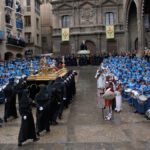 Los cofrades portan la peana del Cristo Yacente al centro de la plaza España de Alcañiz durante la procesión del Santo Entierro