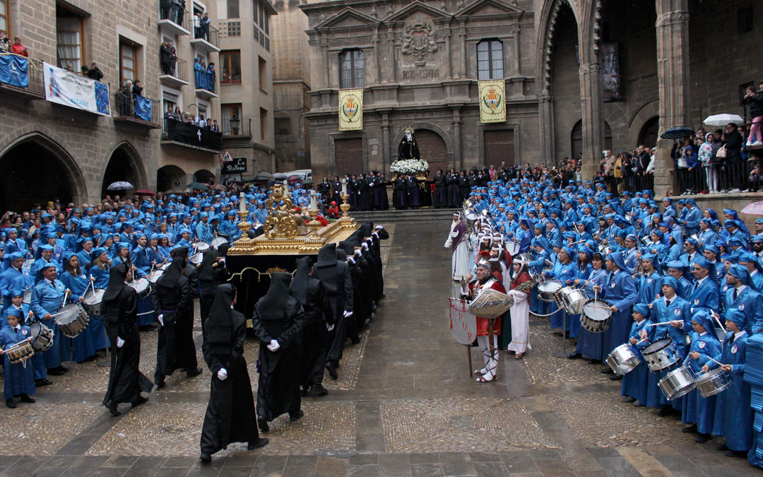 Los cofrades portan la peana del Cristo Yacente al centro de la plaza España de Alcañiz durante la procesión del Santo Entierro
