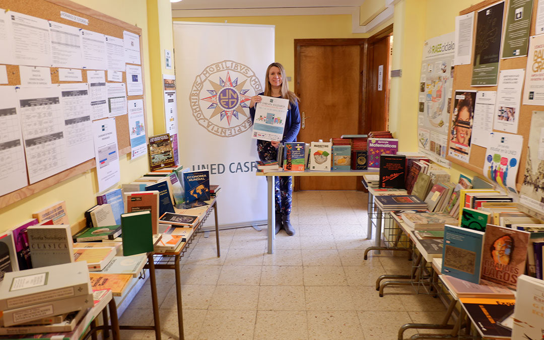 Merche Catalán, secretaria de UNED Caspe, junto a los libros donados.