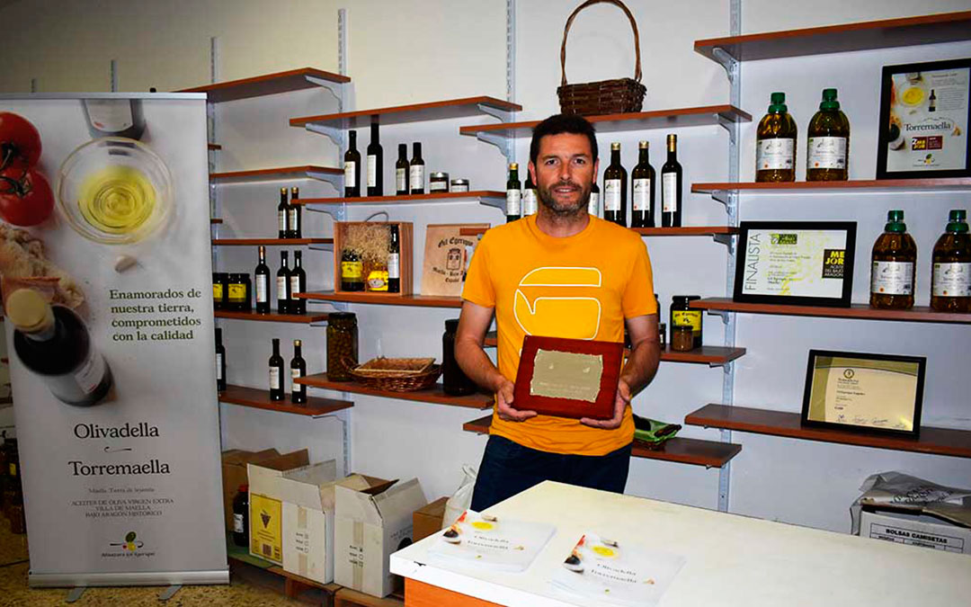 El maestro almazerero David Gil en las instalaciones de la empresa, junto a algunos de los reconocimientos recibidos.