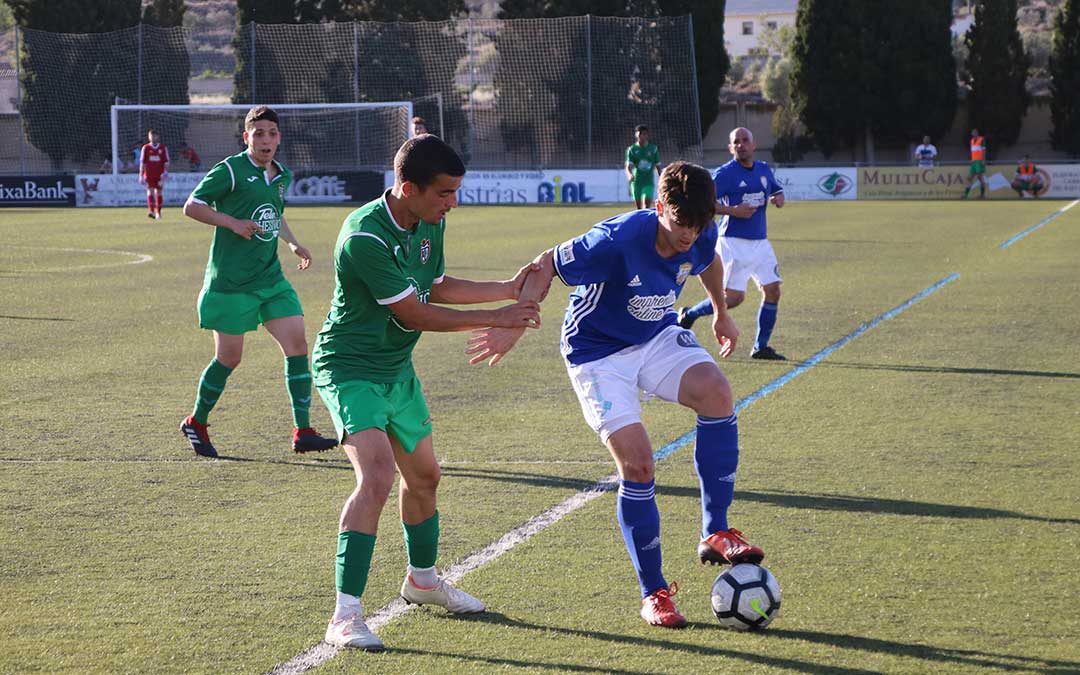 El jugador del Caspe Javier Muniesa controla un balón ante la oposición del rival
