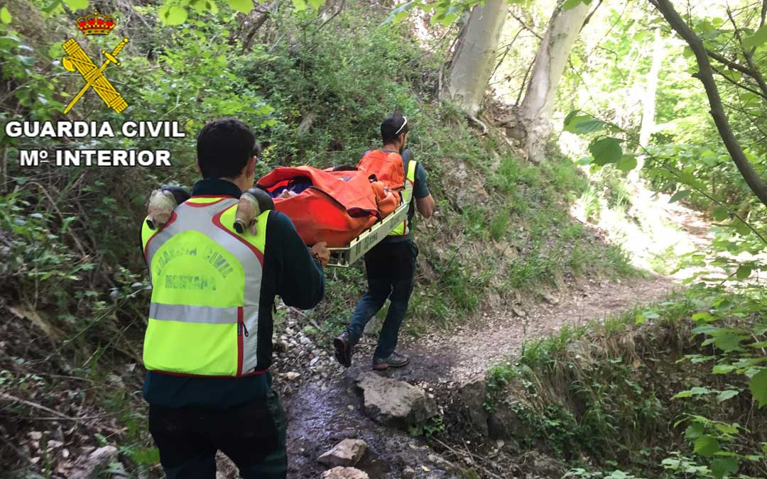 Dos agentes de la Guardia Civil cargaron con el herido en una camilla hasta un lugar de fácil acceso para el helicóptero