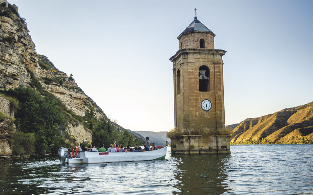 Ver de cerca el campanario del pueblo viejo de Fayón, el único elemento que no está sumergido bajo las aguas, es uno de los atractivos de los paseos en lläut de Fayón. Foto: Turismo Fayón