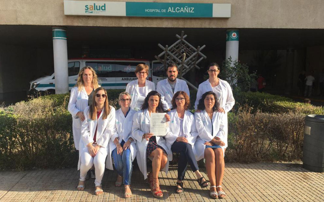 Auxiliares administrativos del Salud posan ante el Hospital de Alcañiz con la queja que presentaron en su día ante el Justicia y que ha surtido efecto con el anuncio del concurso de movilidad. // Heraldo