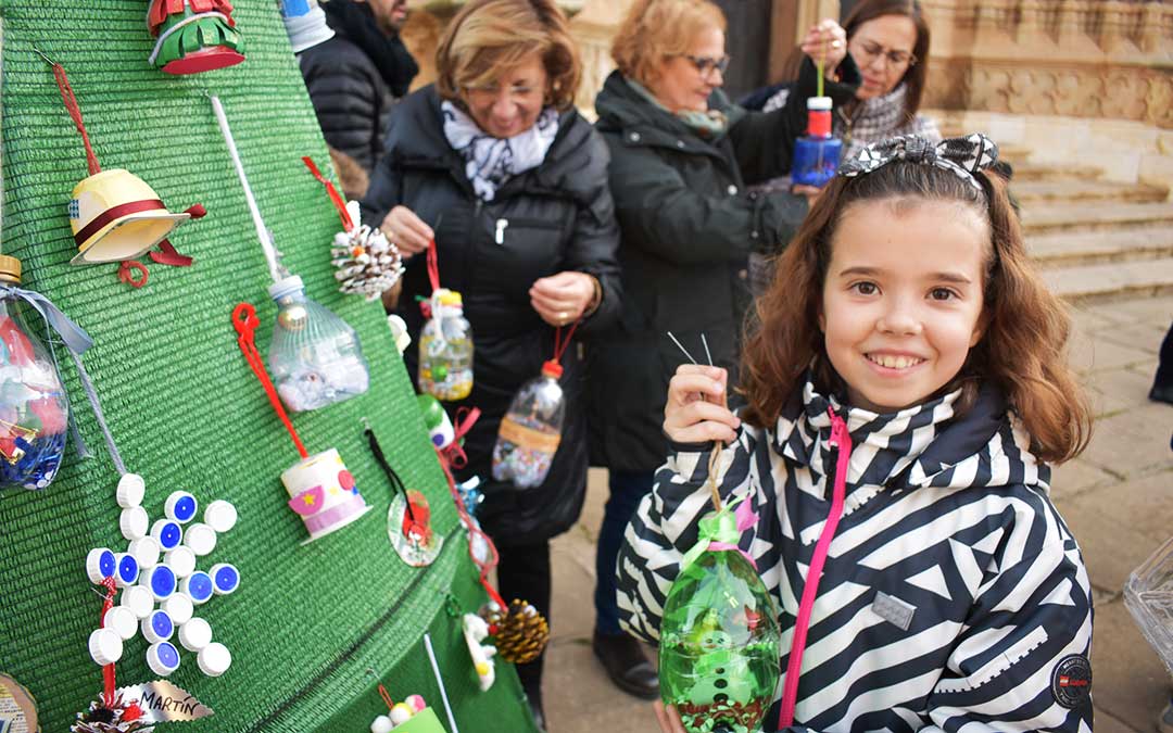 Una niña de sexto del Alejo Lorén decorando el árbol en Caspe.