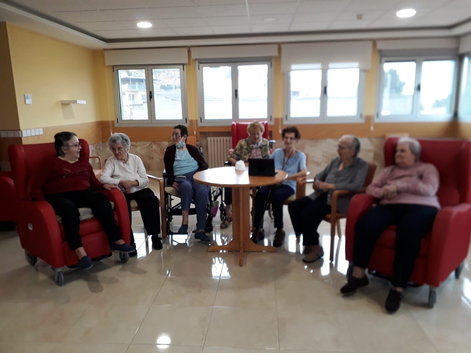 Residentes del asilo con una de las tablets donadas por las asociaciones.