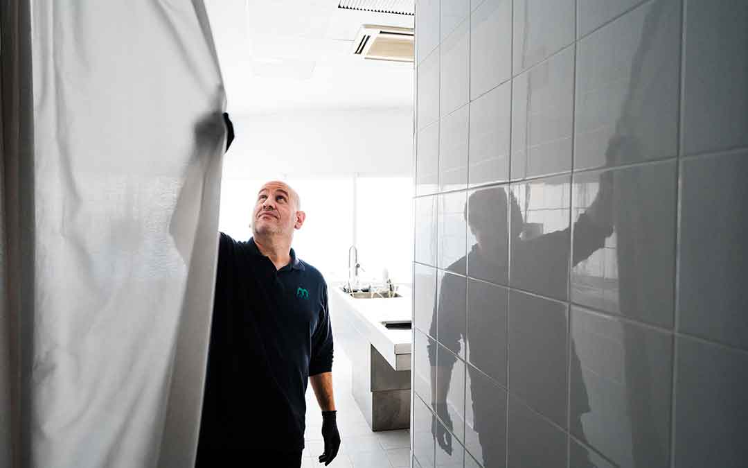 Trabajador de una funeraria de Caspe cerrando la cortina. Imagen: Cesáreo Larrosa.