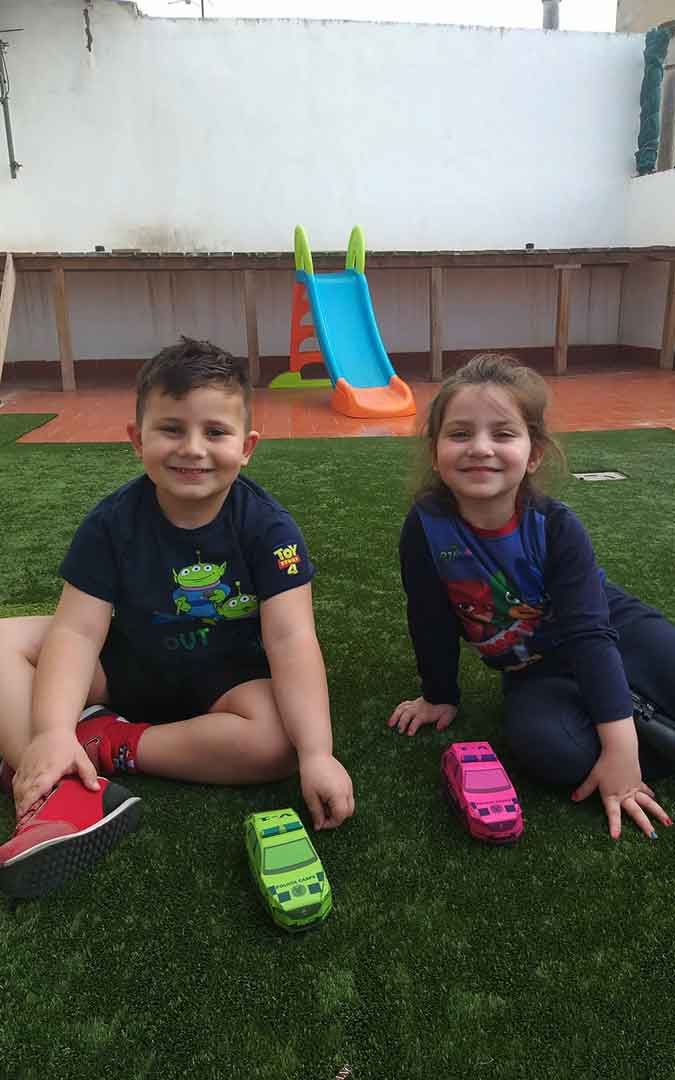Niños con sus coches de Policía Local de Caspe hechos de papel.