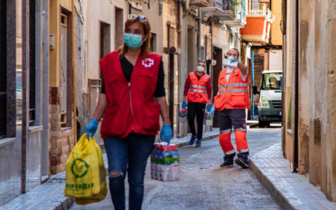 MIembros de Cruz Roja realizando reparto de kits de alimentos durante la pandemia. / L. C.