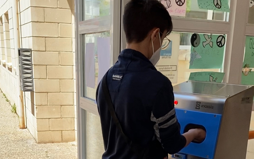Un alumno se desinfecta las manos con el equipo instalado en el acceso principal al centro./Comercial ADIM