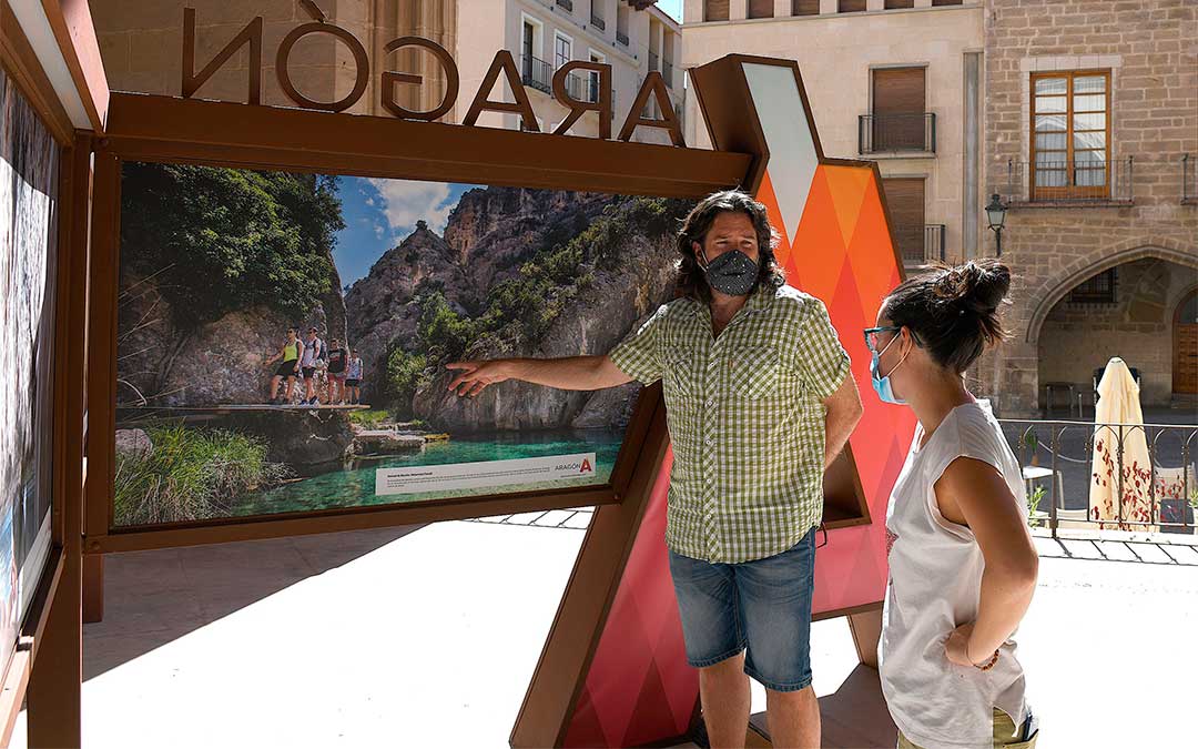 Visita del concejal de Turismo, Jorge Abril, y la técnica de la DG de Turismo, Marta Güell, a la exposición 'Este verano salimos juntos' en la Lonja de Alcañiz./ Ayto. de Alcañiz
