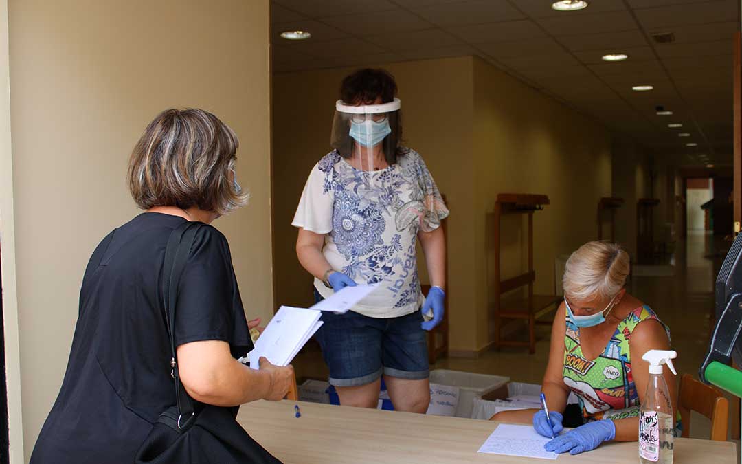 Personal municipal entregando mascarillas a una vecina.