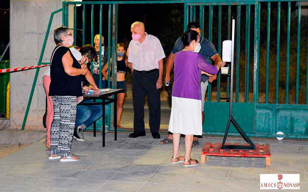 Vecinos entrando en el patio del colegio de Nonaspe para disfrutar de la actuación del sábado, llevando a cabo las medidas de higiene necesarias. Imagen: Amics de Nonasp.