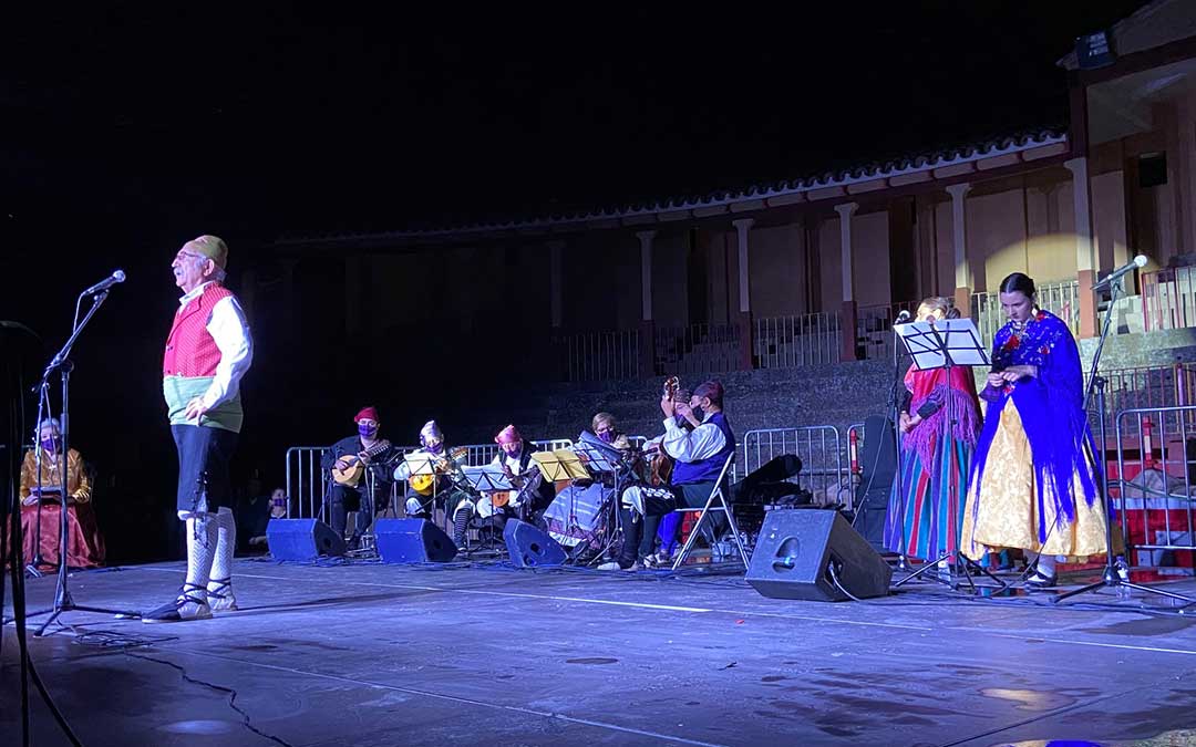 Uno de los joteros participantes cantando ante el público albalatino. Al fondo la rondalla con mascarilla cachirulera./ A.M.