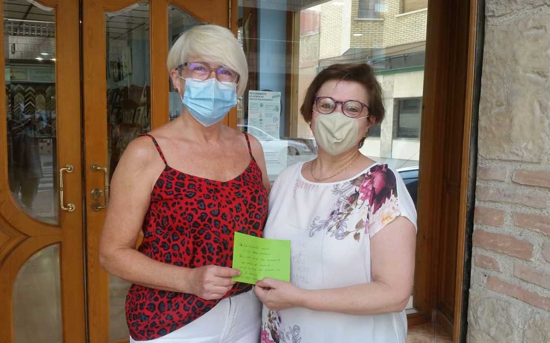 Pili Omedes (izda.) durante la entrega del primer donativo de 50 euros a AFEDABA-Los Calatravos./ P.O.