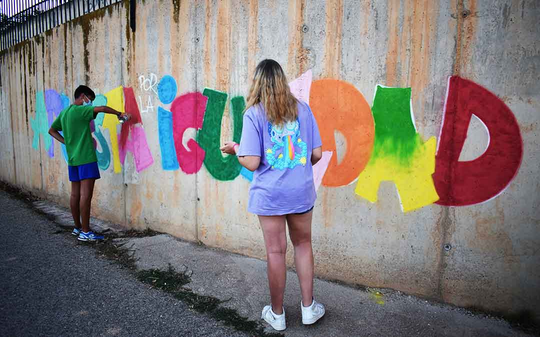 Dos jóvenes terminando el mural.