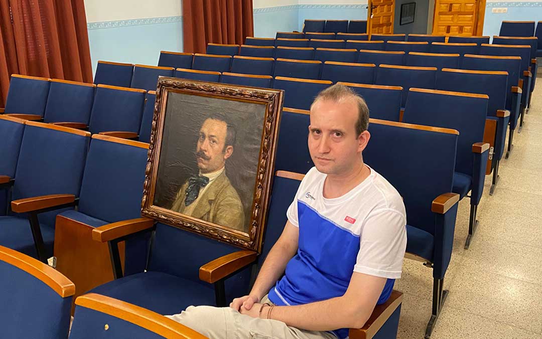 José Antonio Val junto al autorretrato de Gárate (1913) que conserva el Ayuntamiento de Albalate del Arzobispo./ A.M.