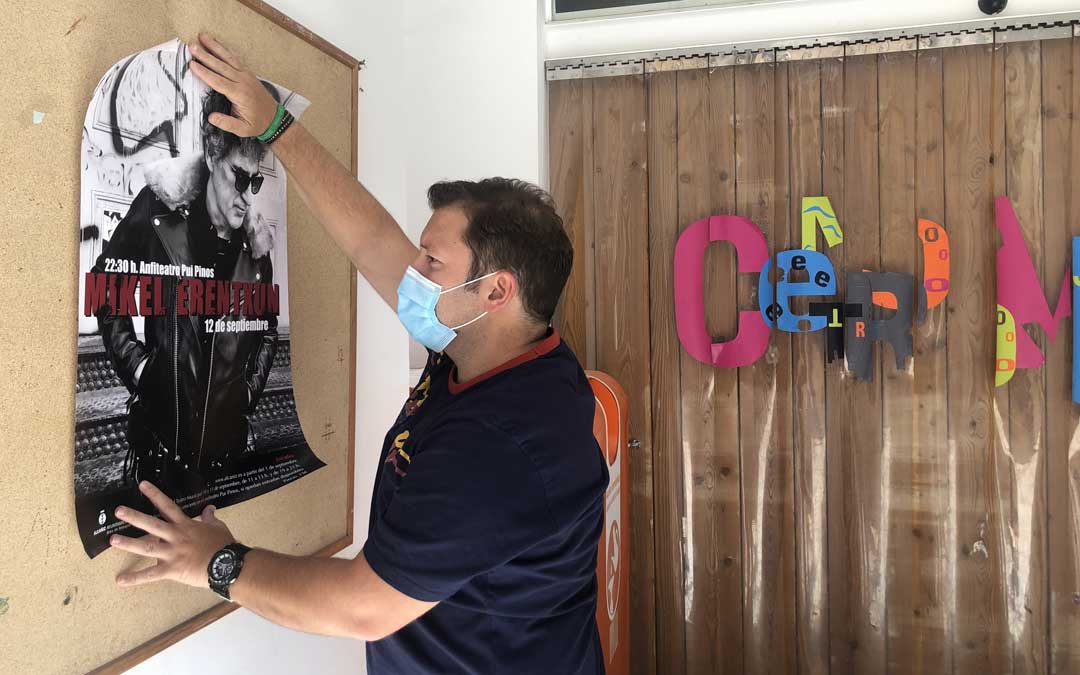 El técnico de Festejos, Tito Lizana, colgando un cartel del concierto de Erentxun