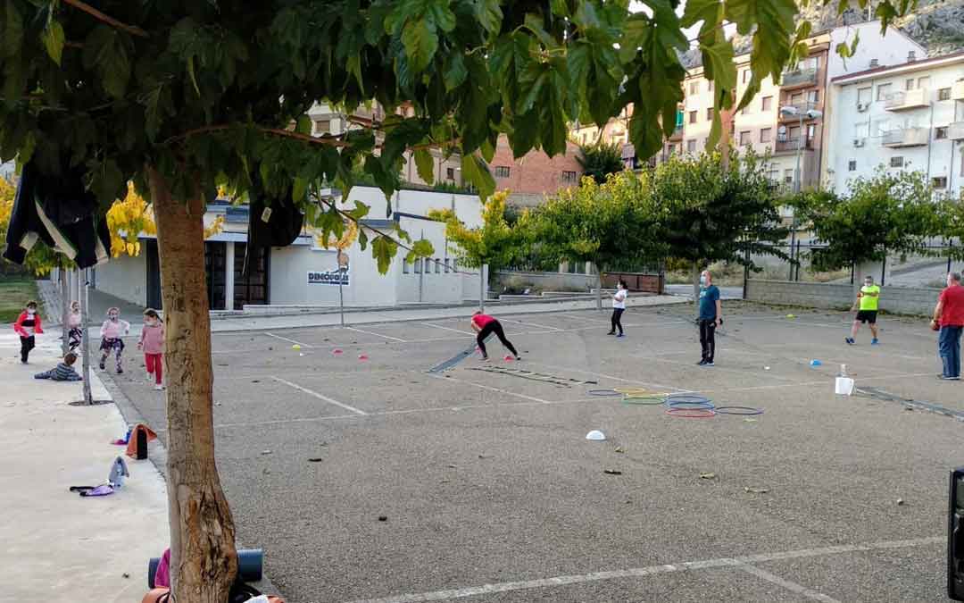 Adultos y niños realizando actividad deportiva en uno de los pueblos de la comarca