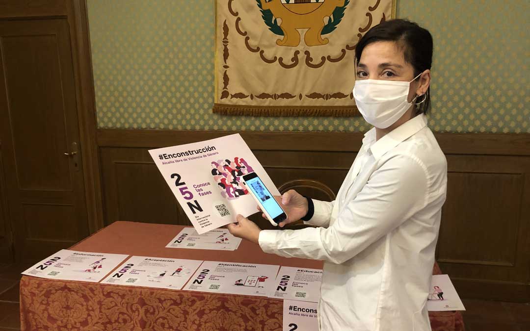 La concejal de Igualdad de Alcañiz, María Milián, mostrando este lunes los carteles con los códigos QR que se colocarán en establecimientos, centros educativos y paneles. A través del móvil se accederá a un cuestionario que habrá que responder / L. Castel