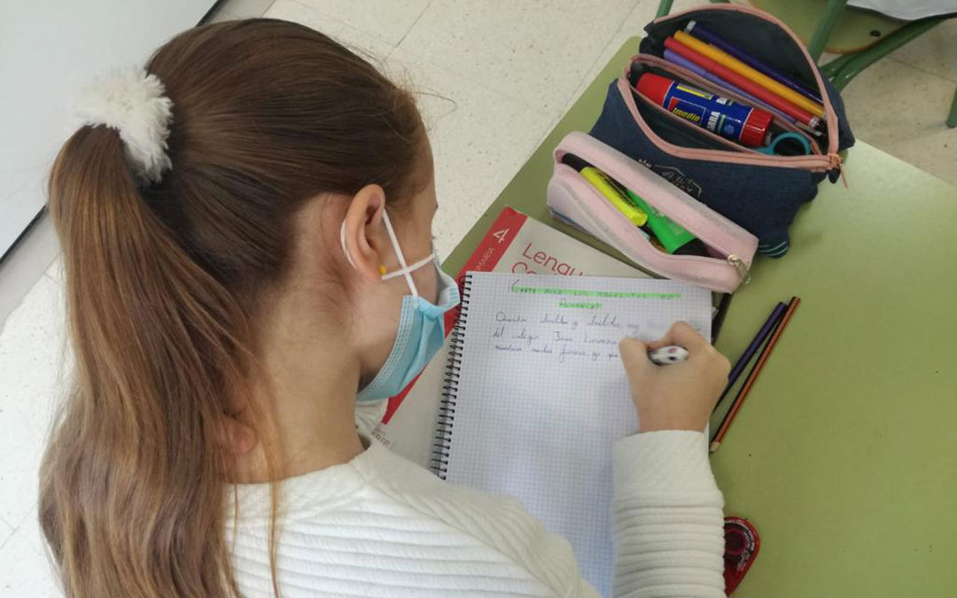 Una de las alumnas del Palmireno escribiendo la carta a una persona mayor del Santo Ángel. / CEIP Palmireno