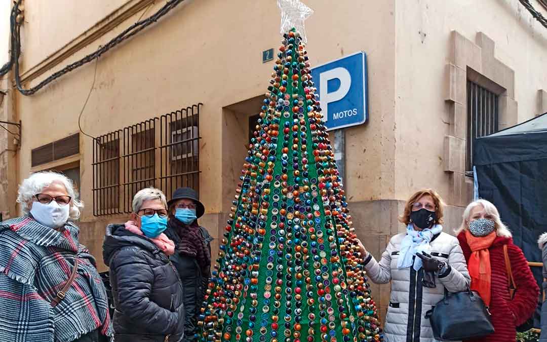 Integrantes de la Asociación de la Mujer Caspolina con uno de sus árboles reciclados.