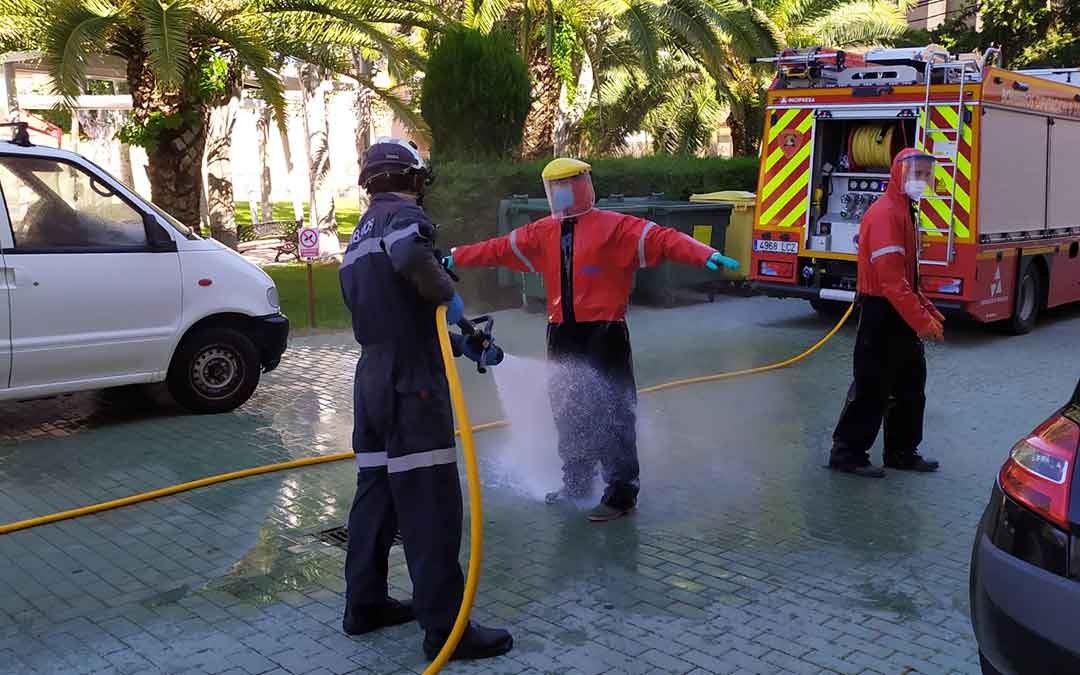 Bomberos del Parque de Caspe desinfectándose después de acceder al centro de mayores Adolfo Suárez.