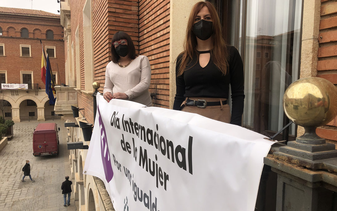 La diputada Susana Traver colocó la pancarta en la fachada del Palacio Provincial junto a la psicóloga Cristina Escrig. / DPT