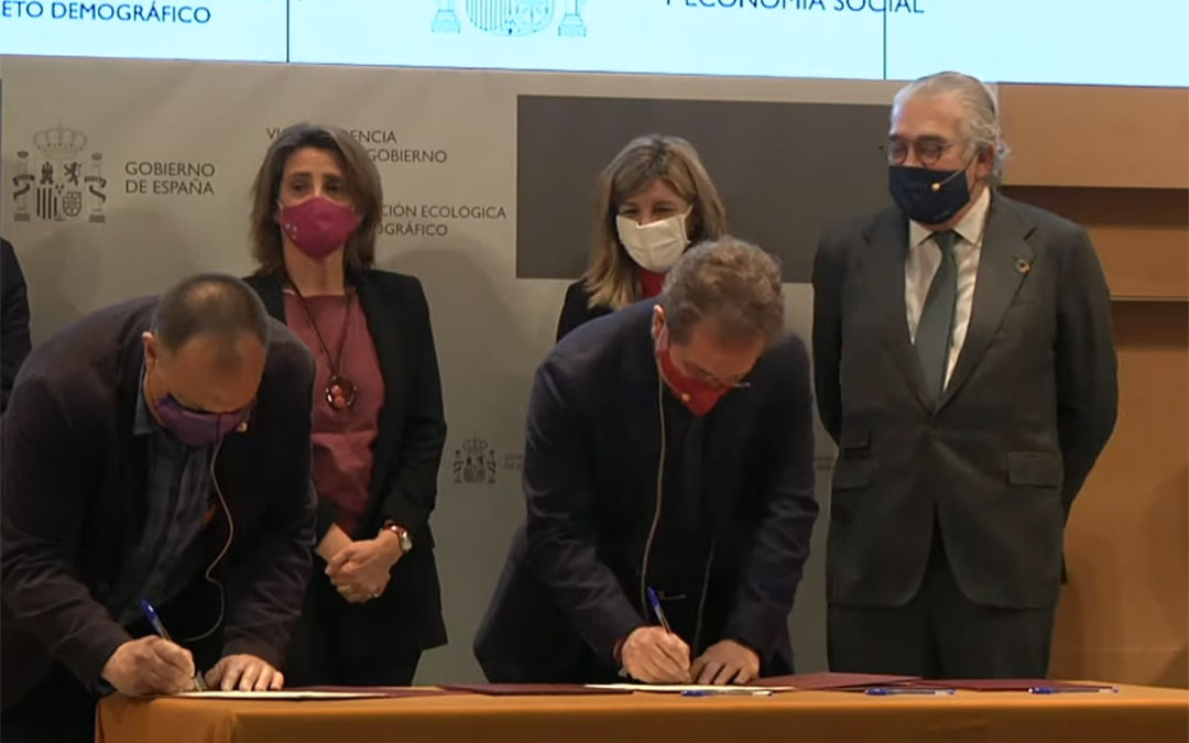 Los representantes sindicales firmando el acuerdo. Detrás, las dos ministras junto a José Bogás. / L. C.