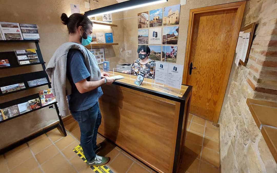 Un joven visitante zaragozano realizando una consulta en la Oficina de Turismo de La Fresneda durante la mañana del domingo. Javier de Luna.