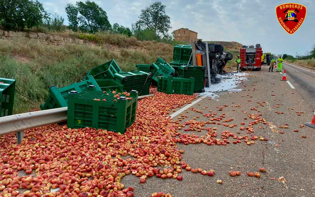 La carga del camión se ha desparramado por la carretera tras volcar el camión./ DPZ