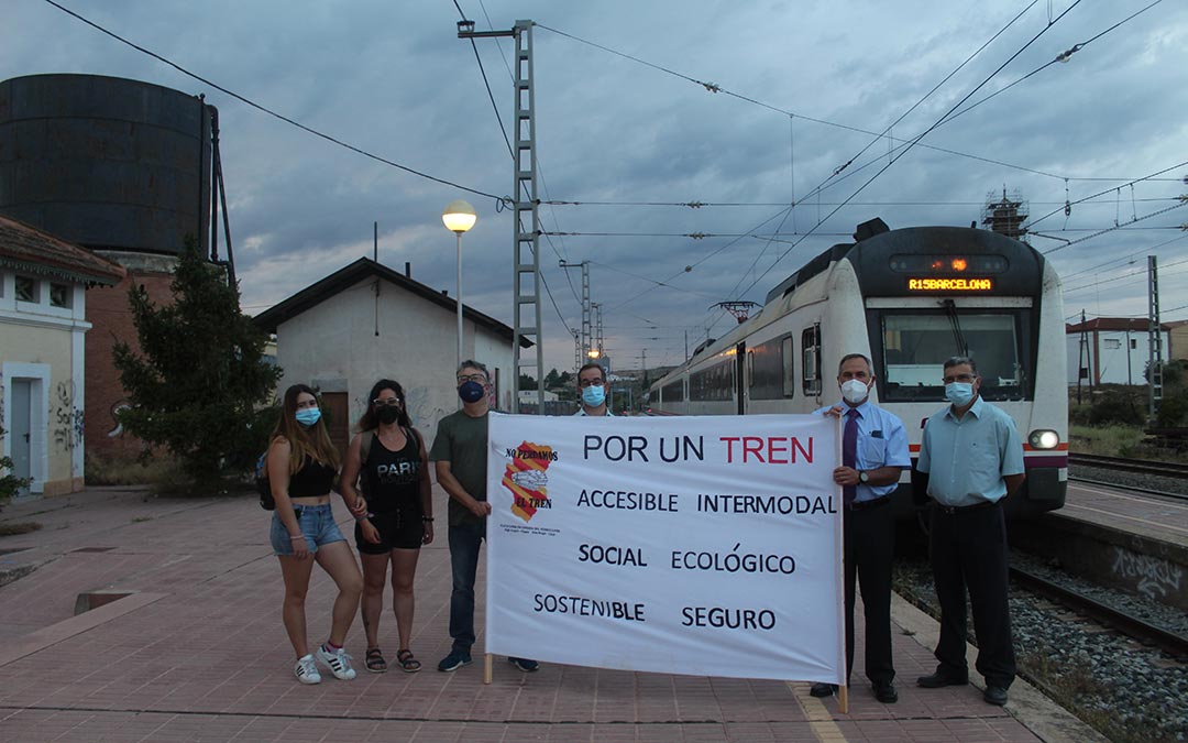 Viajeros y miembros de la Plataforma en Defensa del Ferrocarril en el Bajo Aragón Caspe frente al tren en la mañana de este lunes / Eduard Peralta
