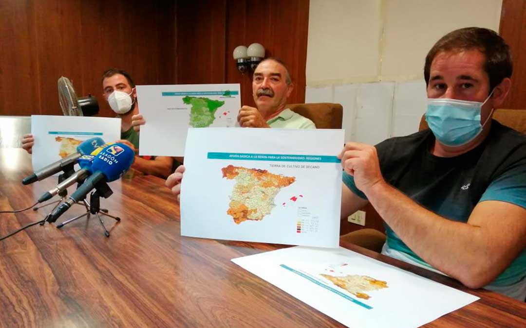 De izquierda a derecha, César Izquierdo, Ricardo Plumed y Francisco Ramo, de la plataforma Agrigate, muestran el mapa de reparto de ayudas. En color claro, las provincias cuyos agricultores percibirán menos dinero / M.A.M.