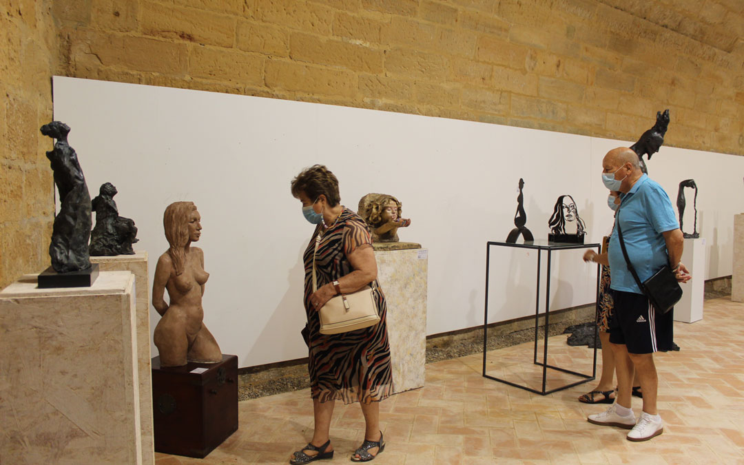 Exposición del ICRE en el Castillo de Albalate del Arzobispo. Una espectadora observa de cerca a 'Serenity', de Dámaris Llaudis. / B. Severino