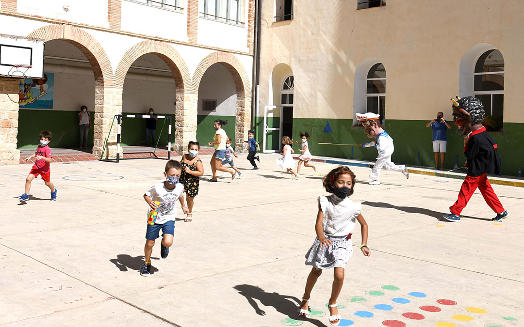 Los cabezudos corriendo detrás de los niños en uno de los patios escolares de Alcañiz. / AYTO. ALCAÑIZ