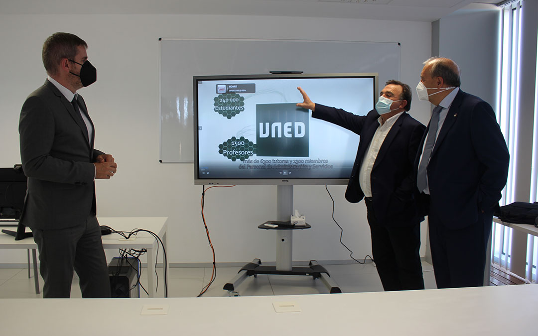 El director de la UNED en Teruel, José Carlos Muniesa, explicando el funcionamiento de la pizarra virtual al alcalde de Alcañiz, Ignacio Urquizu; y el presidente de la DPT, Manuel Rando / L. Castel