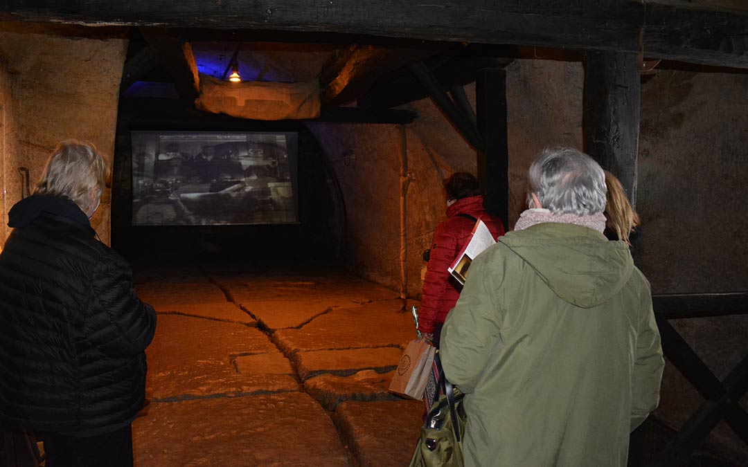 Las turistas prestando atención a la explicación audiovisual en los pasadizos de Alcañiz./I.M.