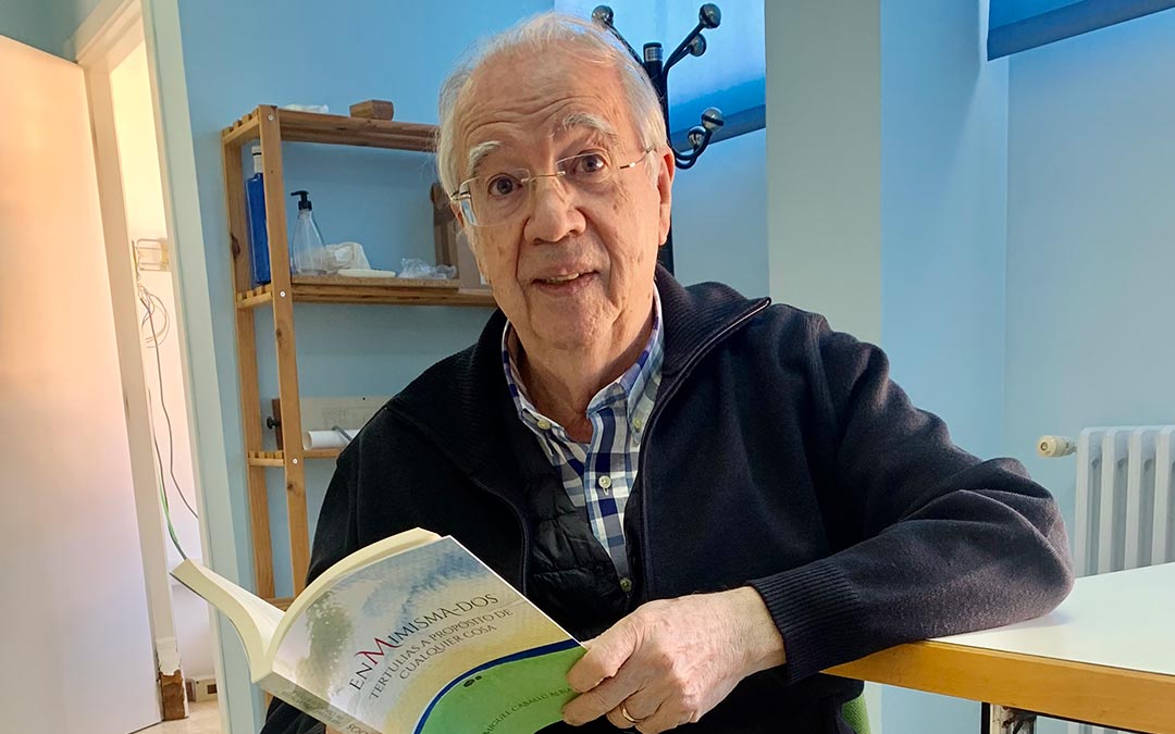 El escritor caspolino Miguel Caballú posa junto a su última publicación en Radio Caspe./ Eduard Peralta