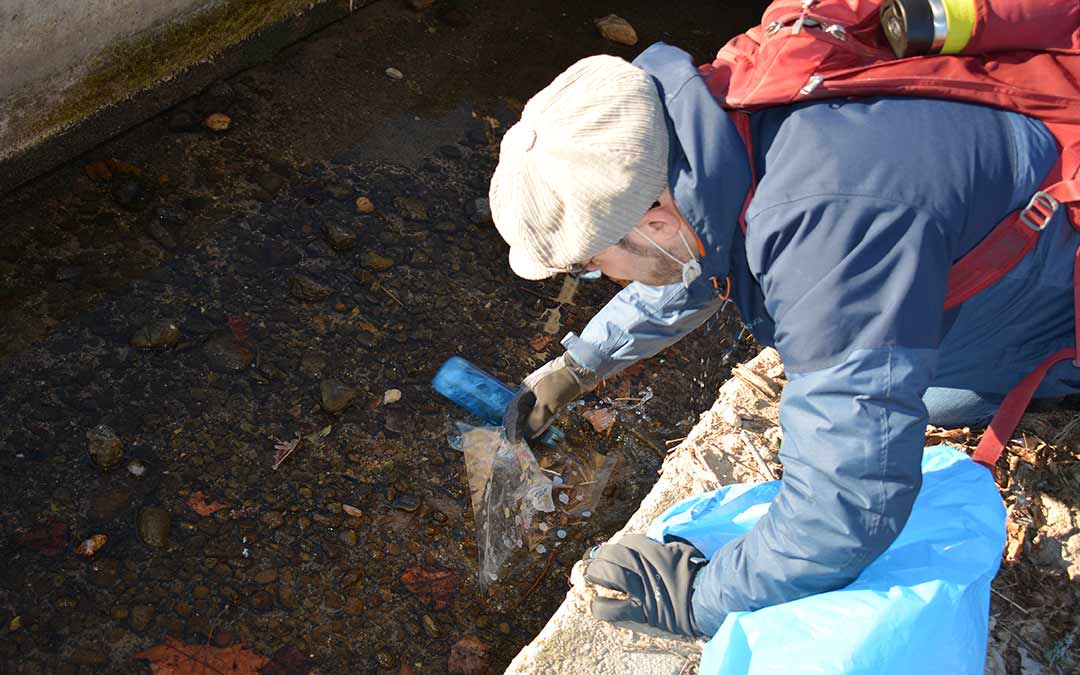 Recogiendo una bolsa de plástico del agua./I.M.