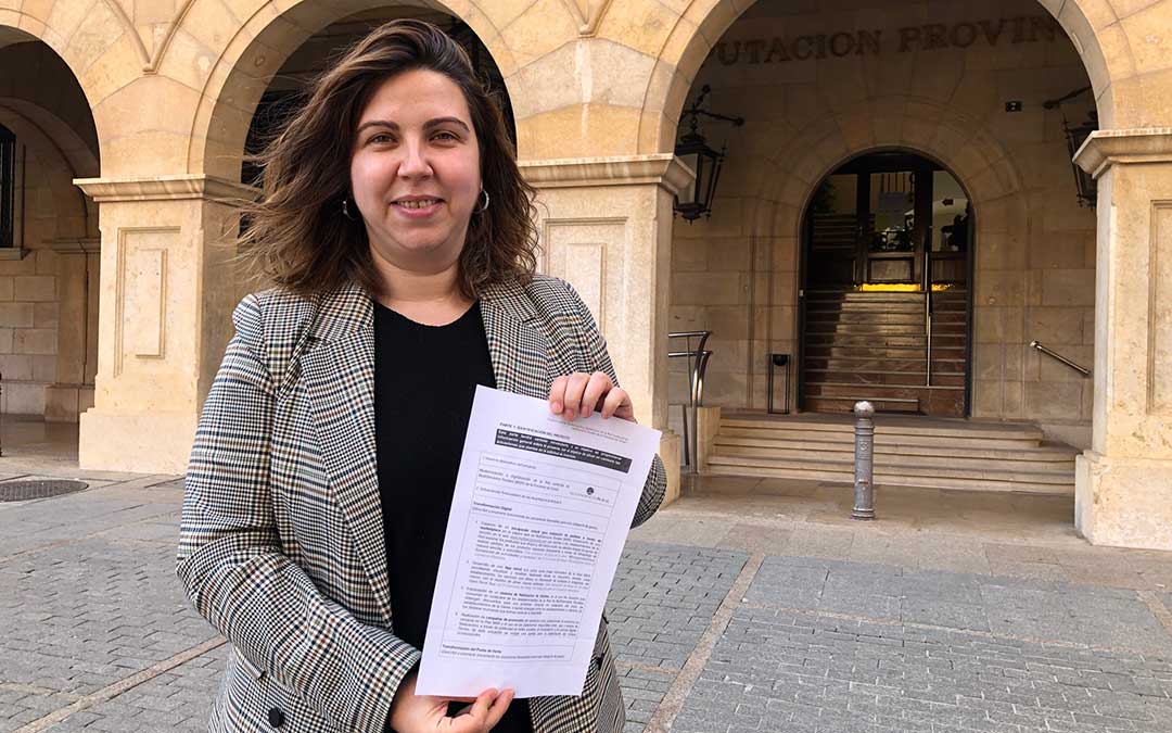 La diputada María Ariño frente al Palacio Provincial con la portada del proyecto seleccionado./ DPT