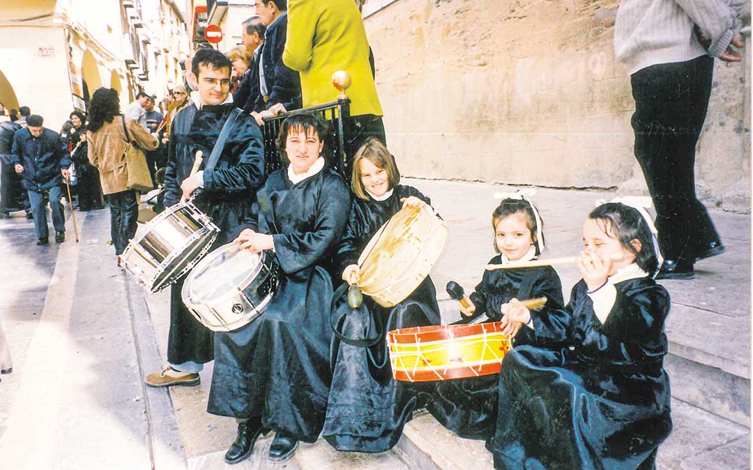 Tomás Martín y su cuñada Mª Carmen Molina, con las entonces pequeñas Ana, Alicia y Esther. Las primas son la tercera generación en seguir con la tradición de los tambores y en el paso de La Cama. / Archivo familia Martín