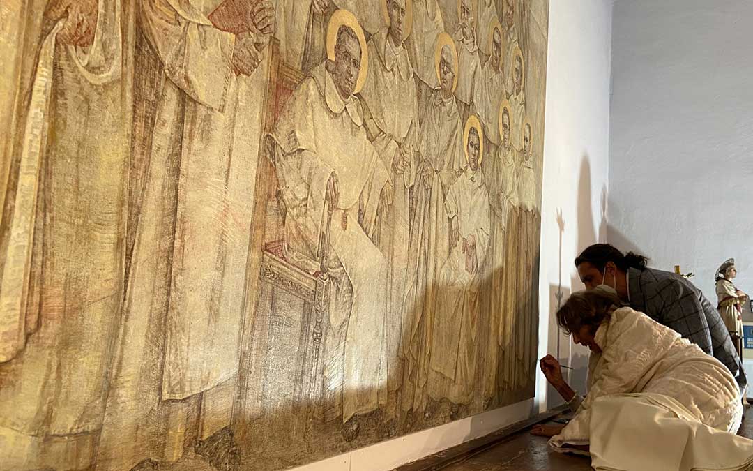 Nati Cañada firma el último cuadro donado al Monasterio del Olivar. Lo hizo en la Sacristía de la Iglesia, ante varios vecinos y amigos./ Alicia Martín