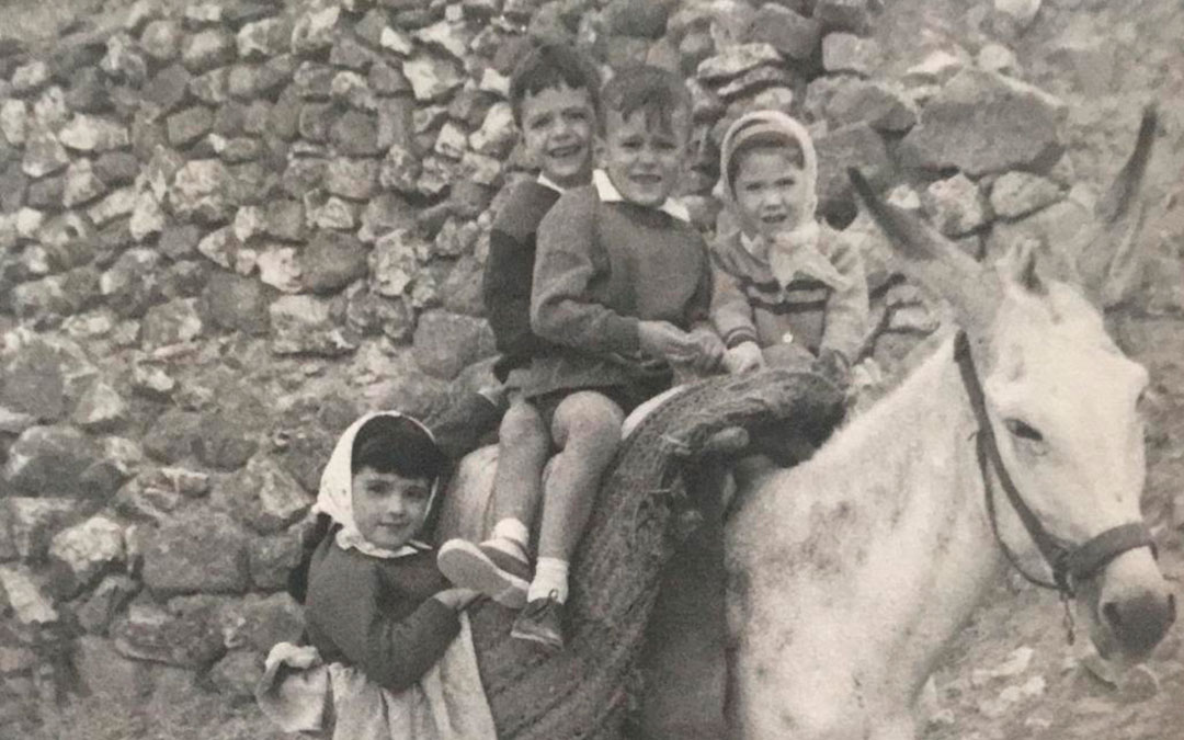 Unos niños montados en un burro, en una imagen sin datar./ Foto cedida