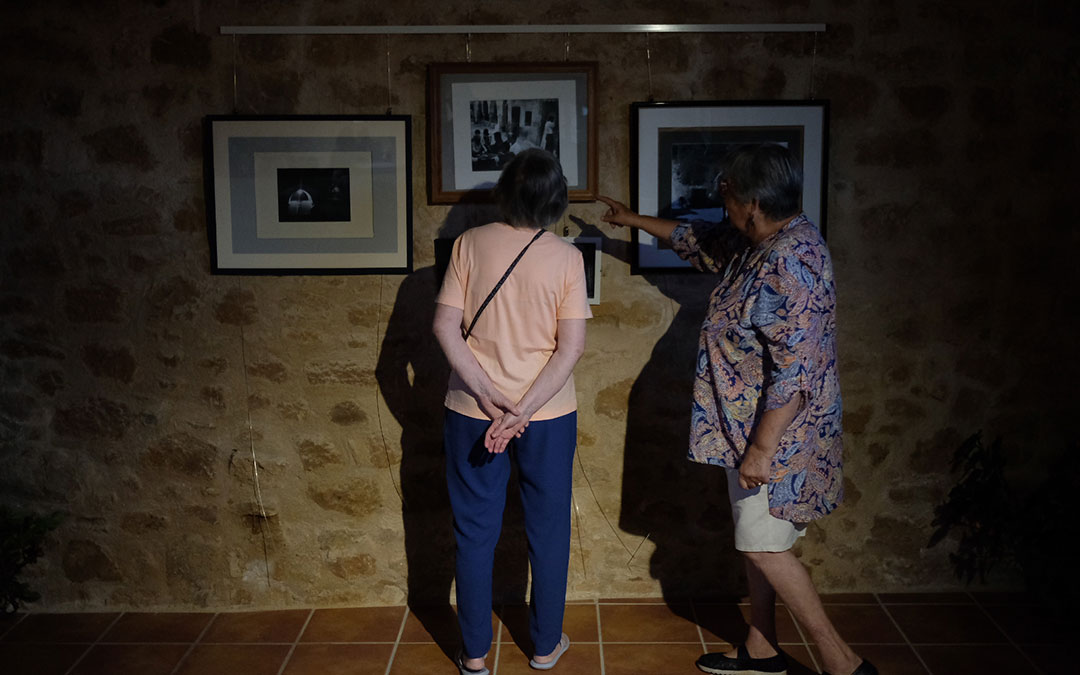 Dos personas comentan las fotografías que integran la exposición de Los Olmos./ Xavier Bertral