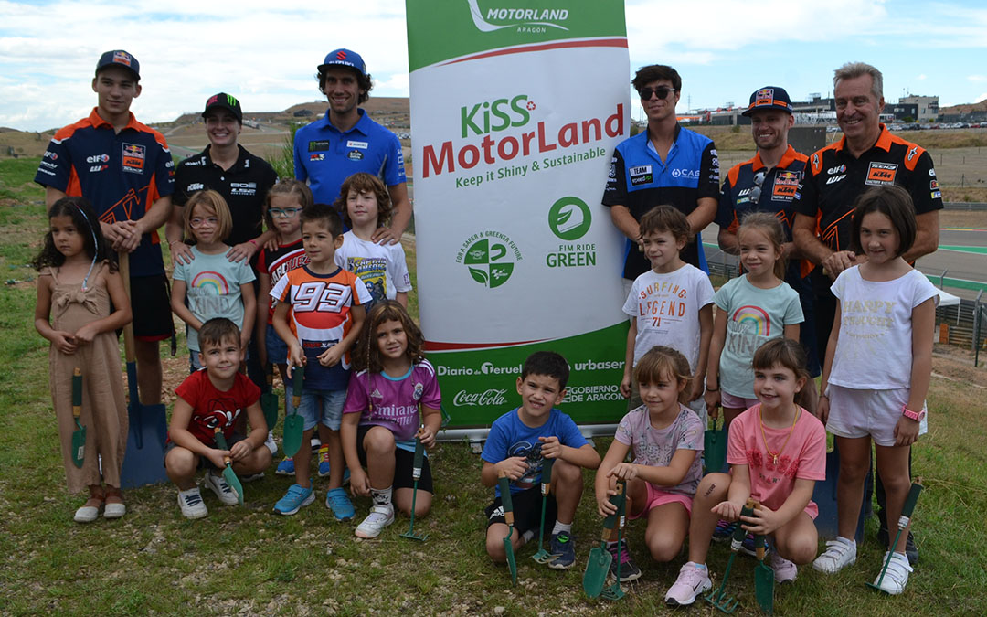 Foto de familia de los pilotos participantes, junto a los alumnos de 1º de Primaria del Colegio Juan Sobrarias y los organizadores del Kiss-Motorland tras la plantada de 25 pinos carrascos que tuvo lugar este jueves en la la pelouse 6./ Javier de Luna