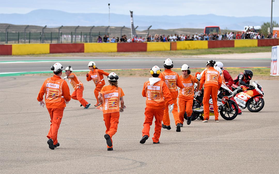 Comisarios yendo al rescate de varias motos tras la caída de Moto3./ L.C.
